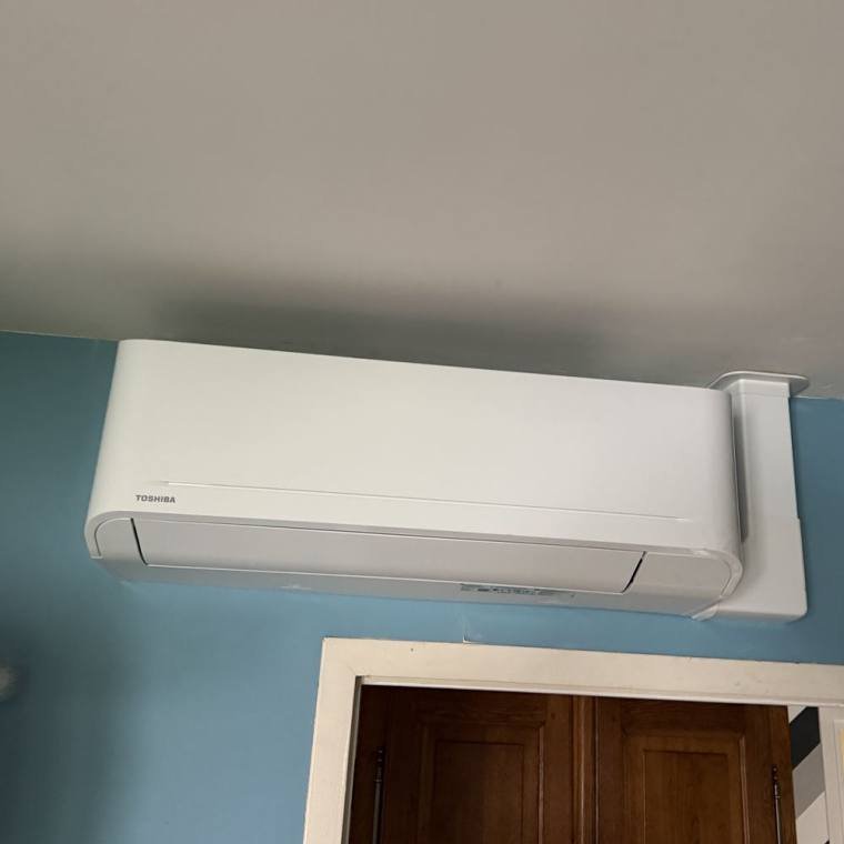 Split de climatisation installé en hauteur dans une chambre