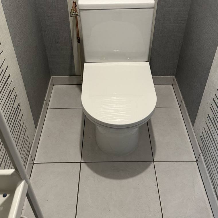 WC installé avec robinet d'arrêt en cuivre et raccordement soigné